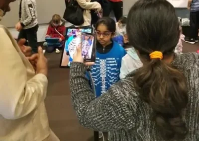 A girl in a skeleton-print shirt is viewed through a phone's augmented-reality app at a STEM event.
