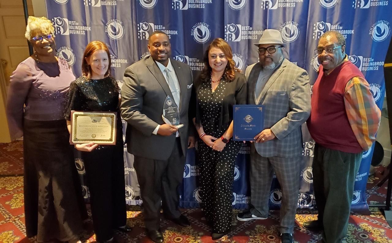 Six people at the Best of Bolingbrook Business awards, holding a Bolingbrook STEM Association certificate and a glass award.